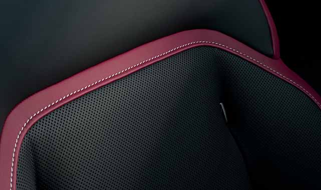 Close-up of the Rolls-Royce Black Badge Spectre’s rear seats, showcasing premium leather, intricate stitching, and the Black Badge emblem.