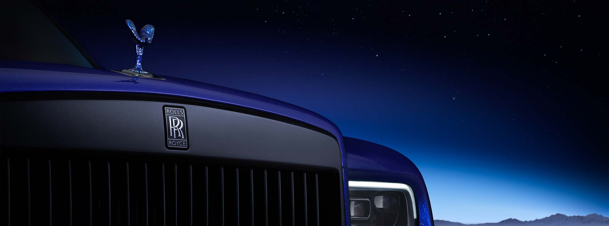 Rolls-Royce Cullinan front grille and headlights under stary moonlit sky